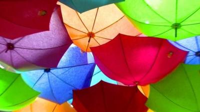 Some of Jacques Demy's colourful umbrellas hanging from a ceiling