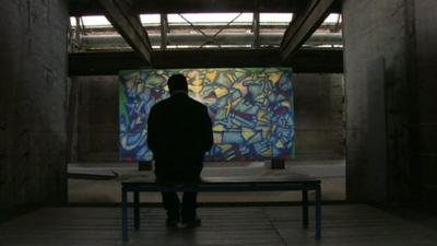 A man looks at an artwork in the factory