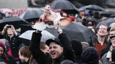 Man holds pig head aloft