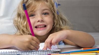 A girl writing with a pencil