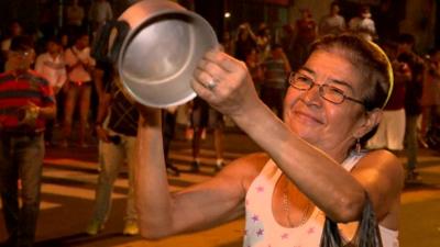 Lady hitting a saucepan in protest at the election