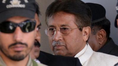 Former Pakistani president Pervez Musharraf (R) is escorted by paramilitary soldiers as he leaves the Pindi High Court