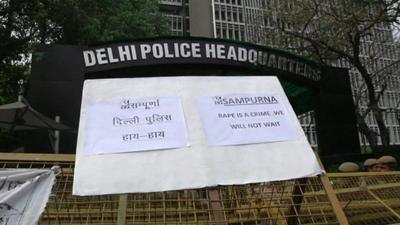 Delhi police headquarters with protesters' placard