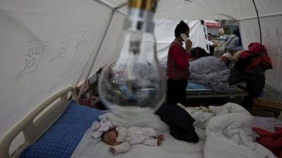 Zhou Xinlong, a three-month-old baby, sleeps at a make shift hospital in the county seat of Lushan in southwestern China"s Sichuan province