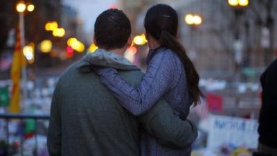 Couple embrace at memorial in Boston