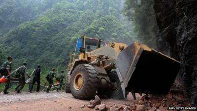 An excavator clearing up a road in China's Sichuan province