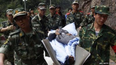 rescuers carrying an injured survivor to an emergency relief centre