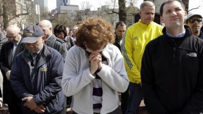 People pause for a moment of silence in Boston