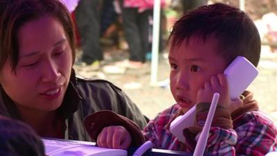 A child talks on a phone at a camp for people affected by the earthquake