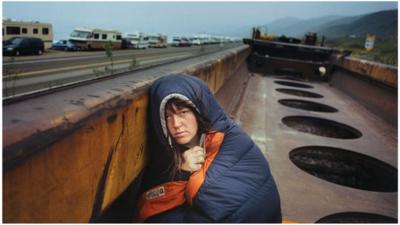 A homeless person riding on a freight train