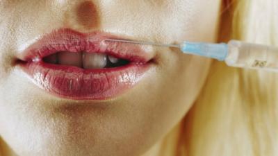 Woman holding collagen needle to her lips