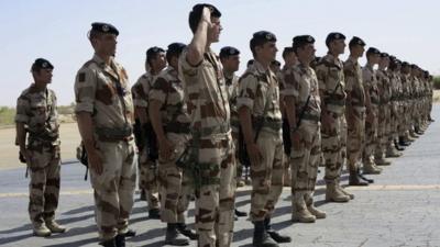 French troops stand at attention during a handover ceremony of the Timbuktu mission from France to Burkina Faso at Timbuktu airport