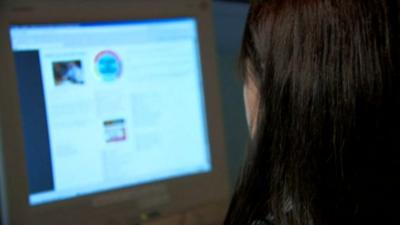 Woman looks at computer screen