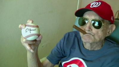 Connie Marrero posing with a self-autographed baseball