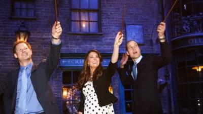 Prince Harry and the Duke and Duchess of Cambridge waving wands on Diagon Alley