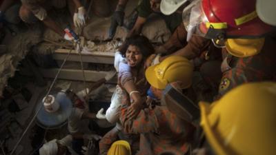 Rescue workers release a garment worker from the rubble of the collapsed Rana Plaza building