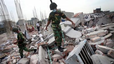 A soldier climbs on debris from the garment factory building that collapsed