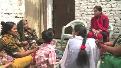 A female campaigner giving a talk to local residents on the importance of voting