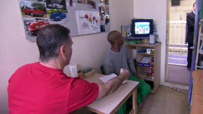 Prisoners watching TV in cell