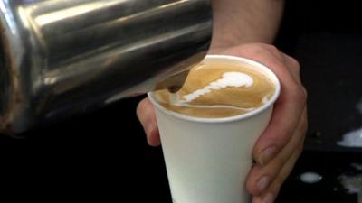 A barista preparing a cafe latte