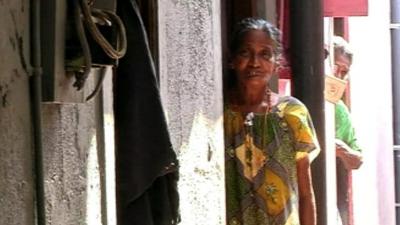 A Sri Lankan woman standing outside her house