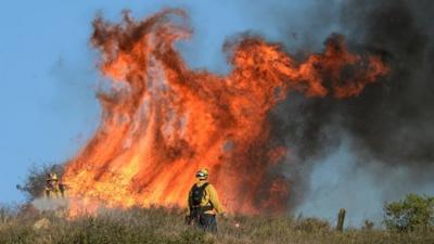 Fire fighters set fires to burn off dry brush to protect homes