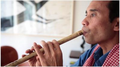 Arn Chorn Pond playing a musical pipe