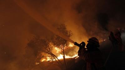 Firefighter hoses flames in California