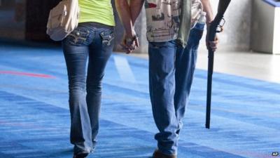 Man and woman holding hands, man holding rifle