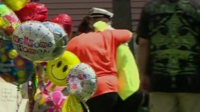 Gina DeJesus being shielded from the crowds as she arrives home