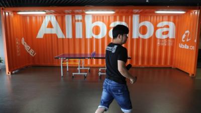 A Chinese Alibaba employee walks through a communal space at the company headquarters in Hangzhou