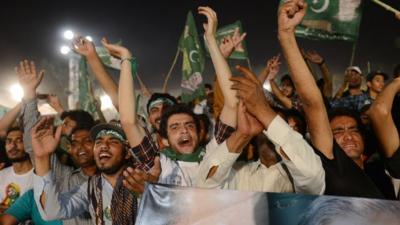 Supporters wave as they greet former Pakistani Prime Minister, Nawaz Sharif, during his campaign closing rally in Lahore