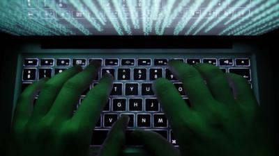 A man types on a computer keyboard