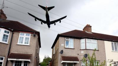 Plane flying over a housing estate outside Heathrow Airport