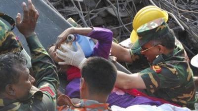 Rescuers carry a survivor pulled out from the rubble of a building that collapsed in Saver