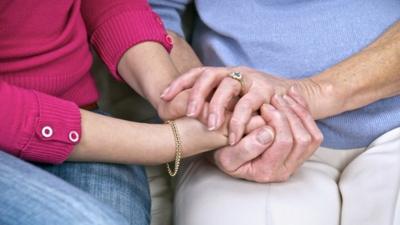 Carer holding hands with woman