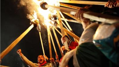 Protesters carry torches during a demonstration outside the National Palace of Culture