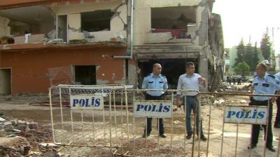 Police near damaged buildings in Reyhanli