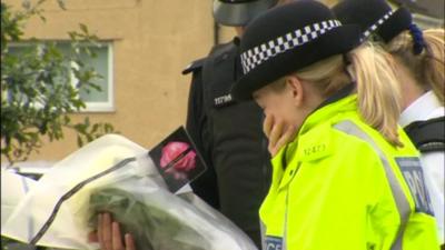 A police officer visits the memorial of PCs Fiona Bone and Nicola Hughes