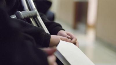 Patient with crutches holds paperwork