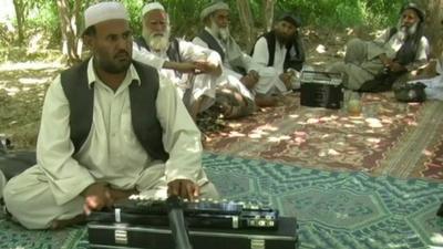 Afghan musician playing a Benjo
