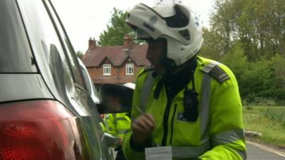 Police officers talks to driver in car