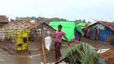 girl walks through makeshift camp