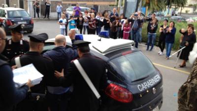 Peppe Pesce being put into a police car