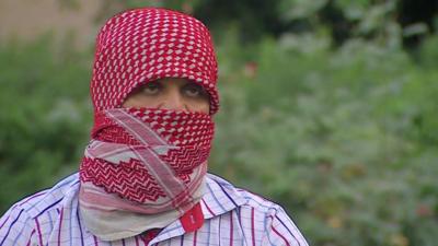 Man with face covered describes recruiting Shia Iraqis to fight alongside Syrian forces