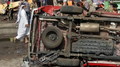 An overturned vehicle at the site of a car bomb attack in front of a popular restaurant in Basra