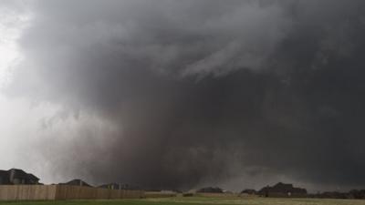 A tornado moves past homes in Moore