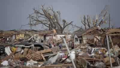 People assess the damage after a powerful tornado ripped through Moore, Oklahoma
