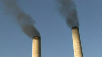 Smoke rising from two chimneys at the sugar mill