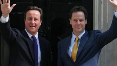 Prime Minister David Cameron (L) and Deputy Prime Minister Nick Clegg, wave as they pose for pictures outside 10 Downing Street in London, on May 12, 2010